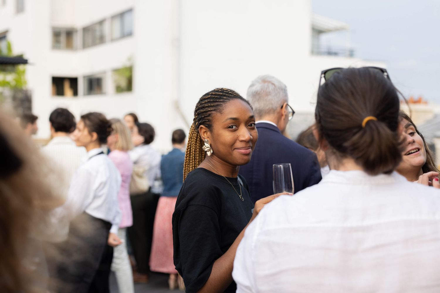 Crowd of event attendees mingling in a bright indoor space.