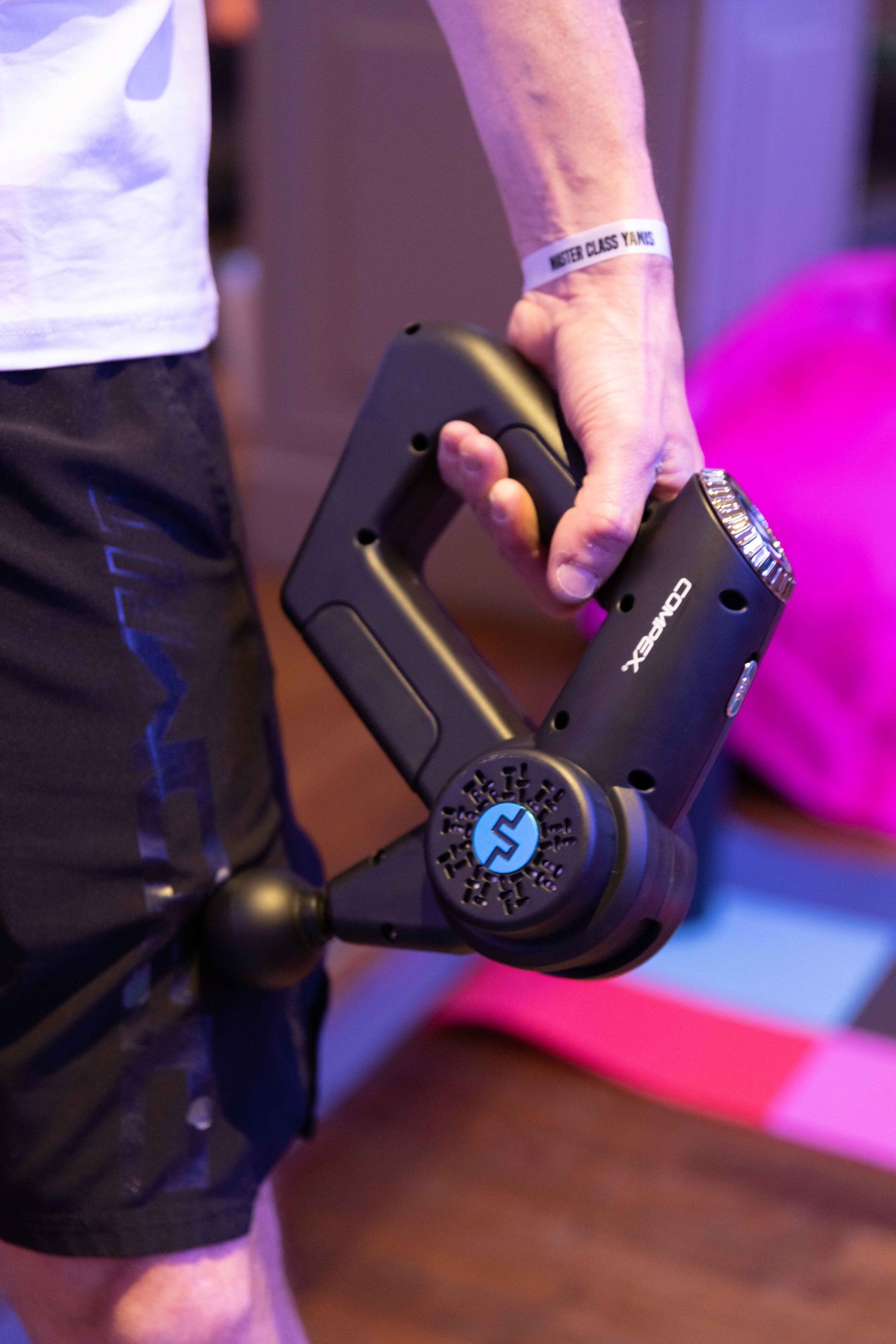 Close-up of fitness equipment being demonstrated with purple and pink lighting effects.