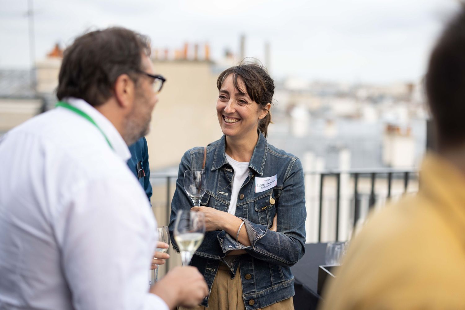 Colleagues sharing a lighthearted moment during a rooftop business gathering.