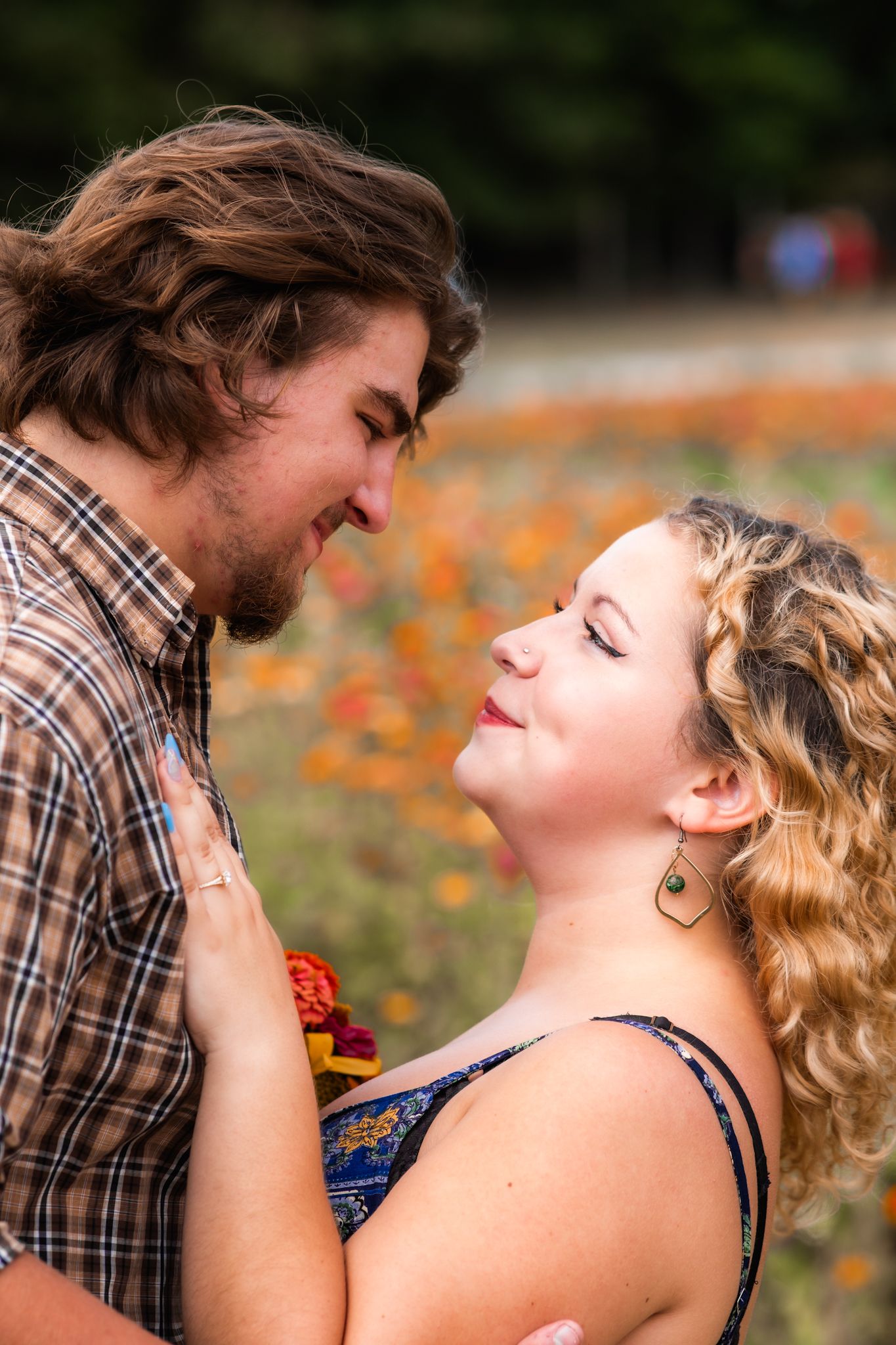 A tender moment between two people against a backdrop of orange wildflowers.