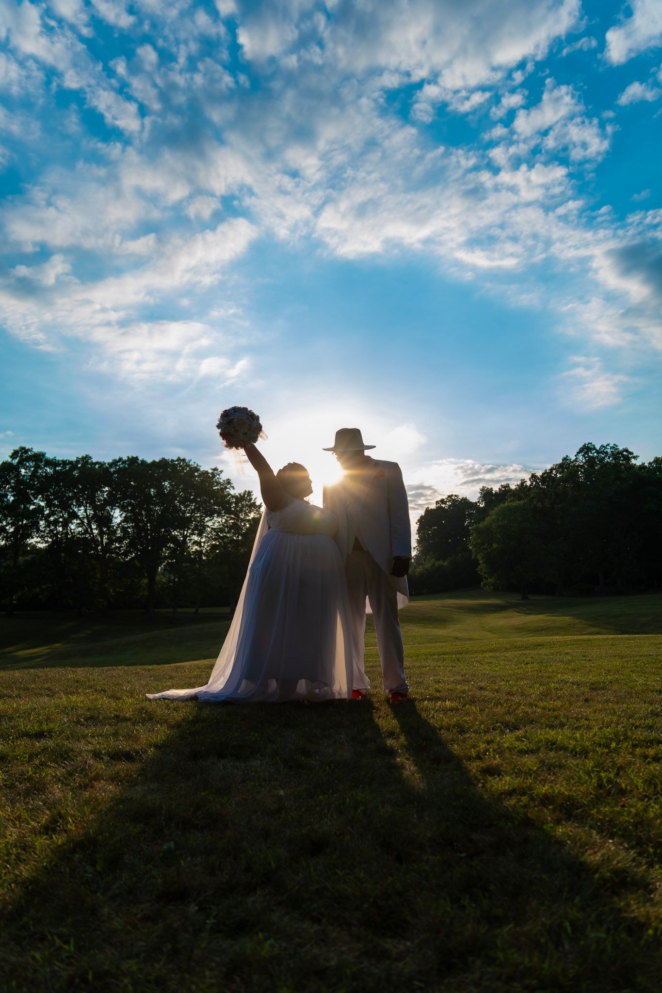 Silhouette of a couple against a sunset sky with dramatic clouds.