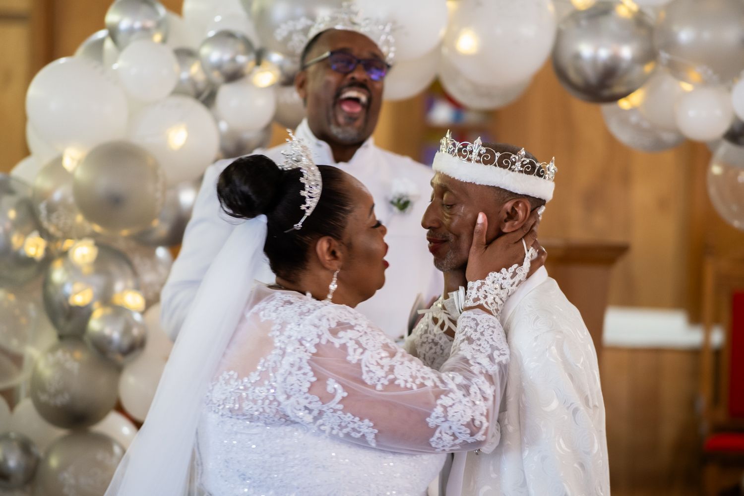 A joyous celebration at a wedding ceremony with beautiful balloon decor and lace details.