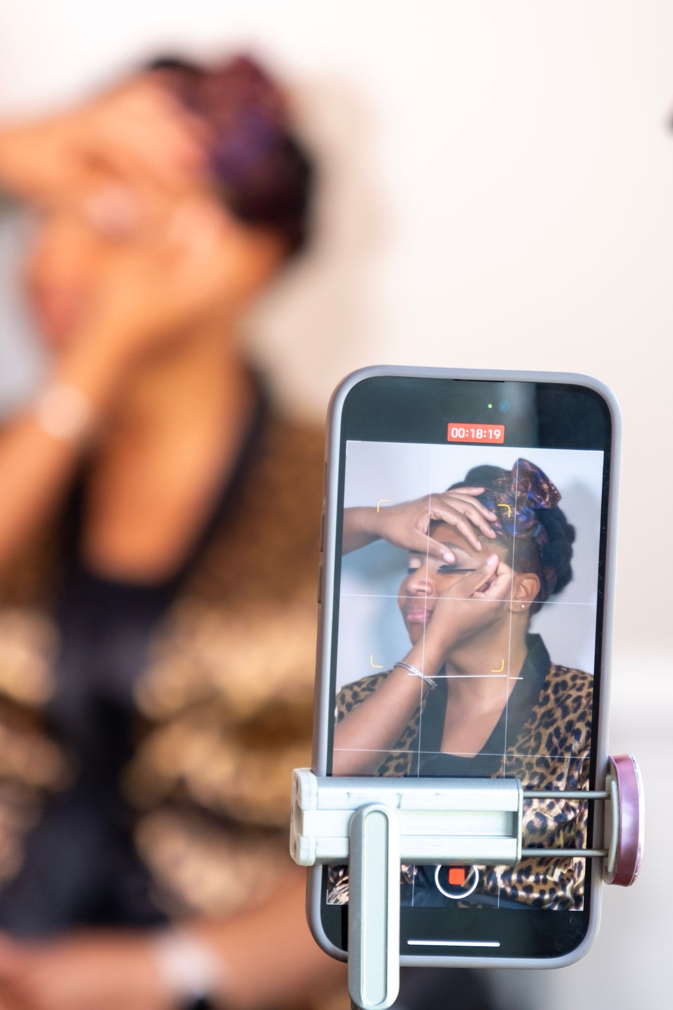 Close up of phone recording makeup application with soft focus background.