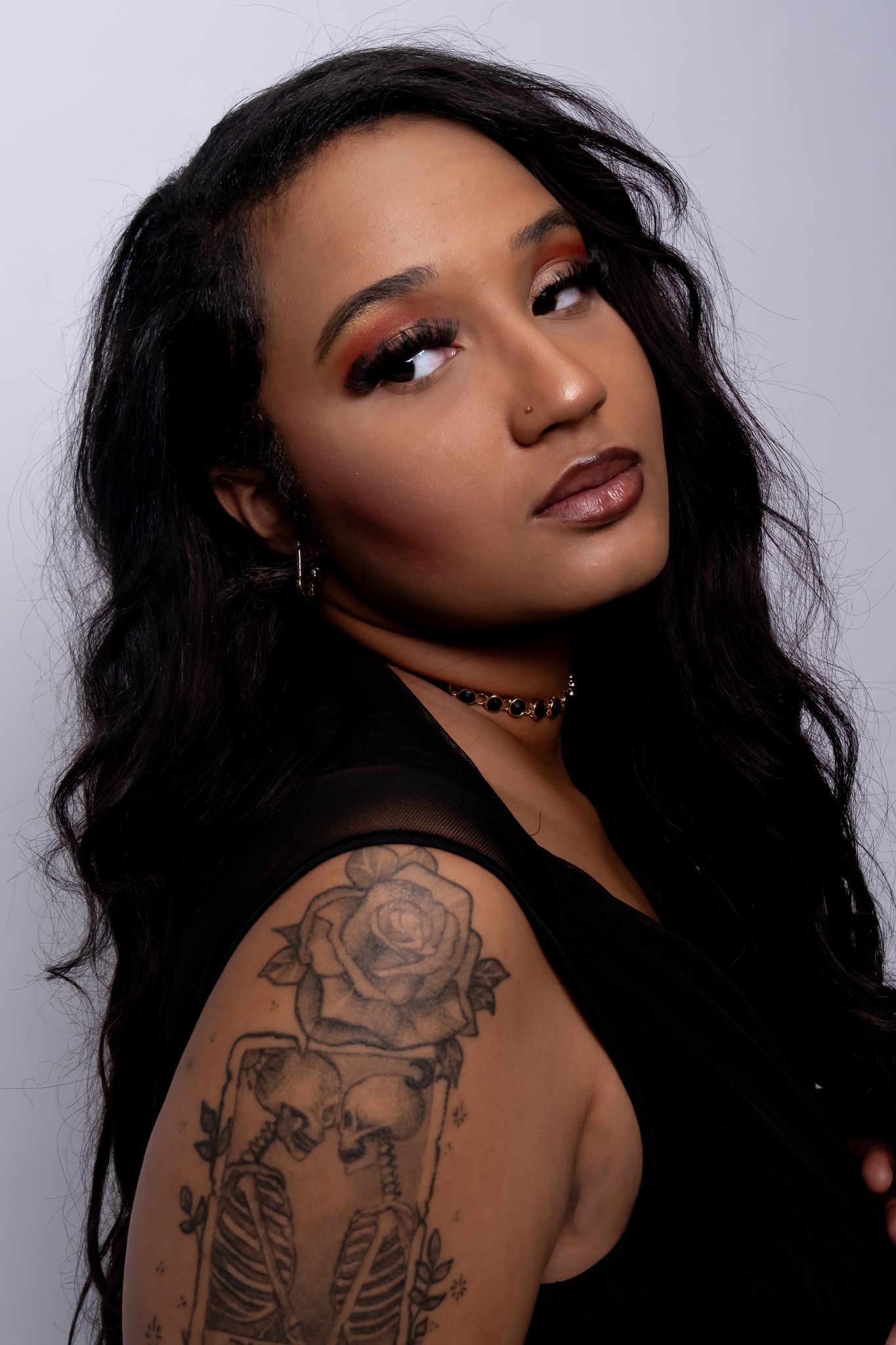 A series of artistic portrait photographs showing long dark hair and intricate rose tattoo artwork on shoulder.