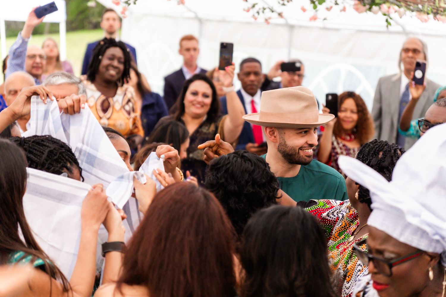 Excited wedding guests celebrate during an outdoor reception.