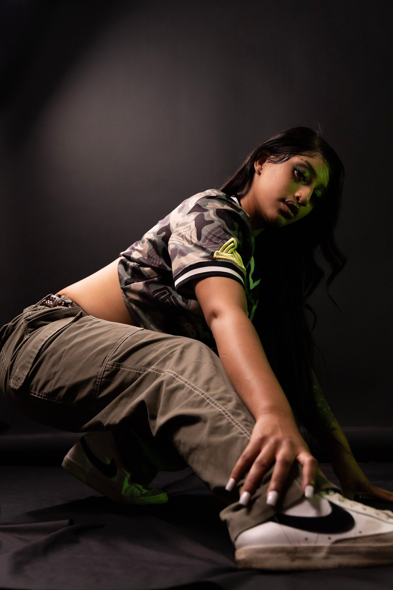 Athletic pose on dark background showcasing urban streetwear and sneakers.