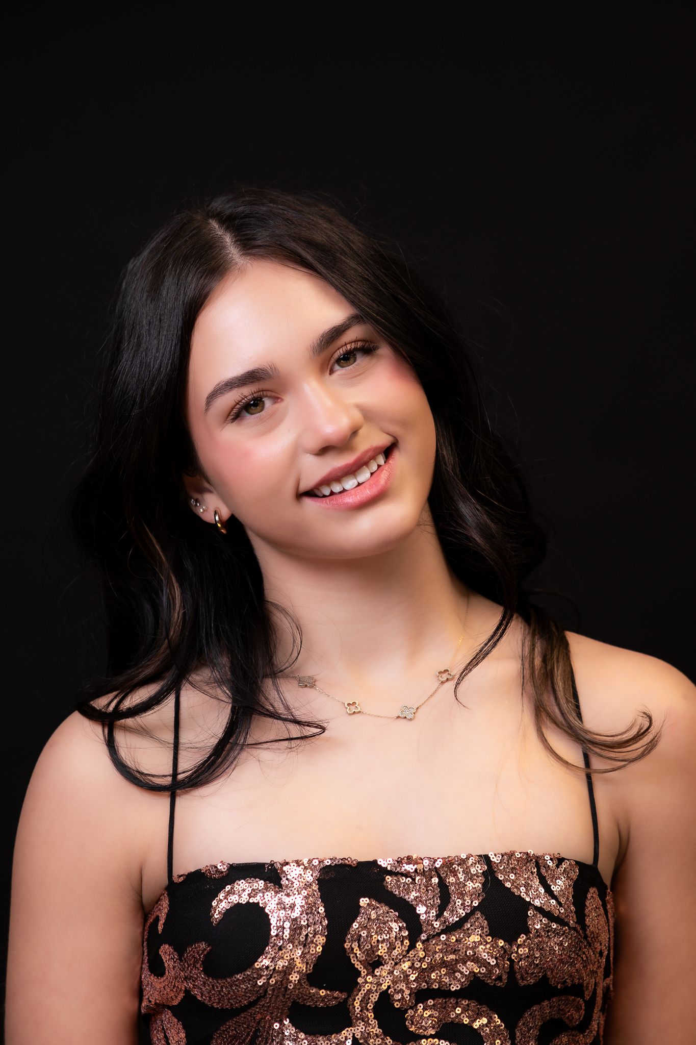 Portrait in sequined strapless top against dark background.