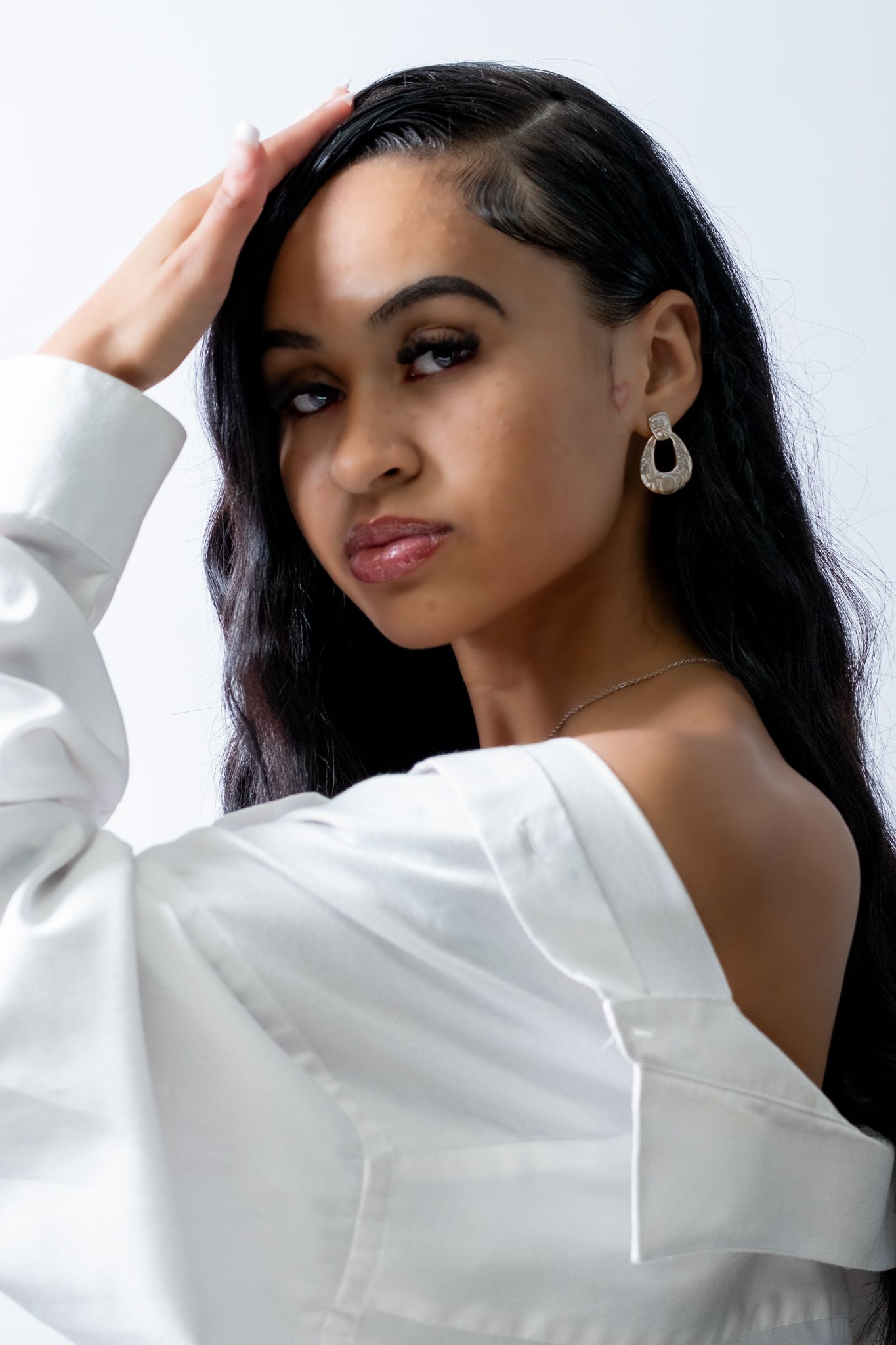 A series of fashion portraits showing a person posing in a white sweater against a light blue background.
