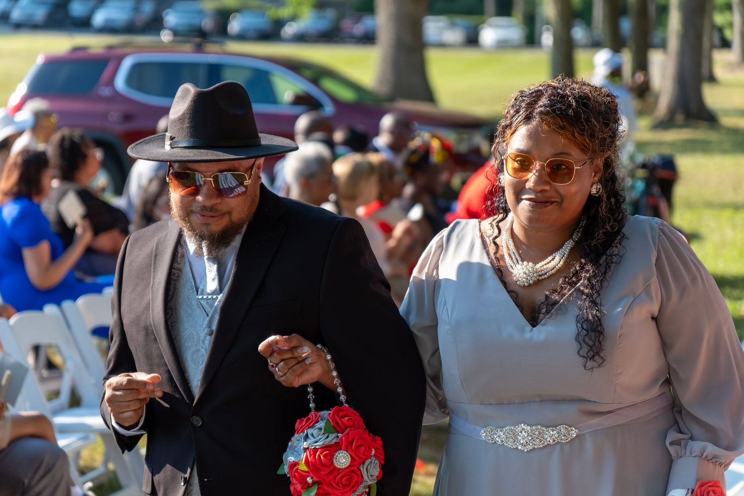 Wedding guests attending an outdoor celebration in formal attire.