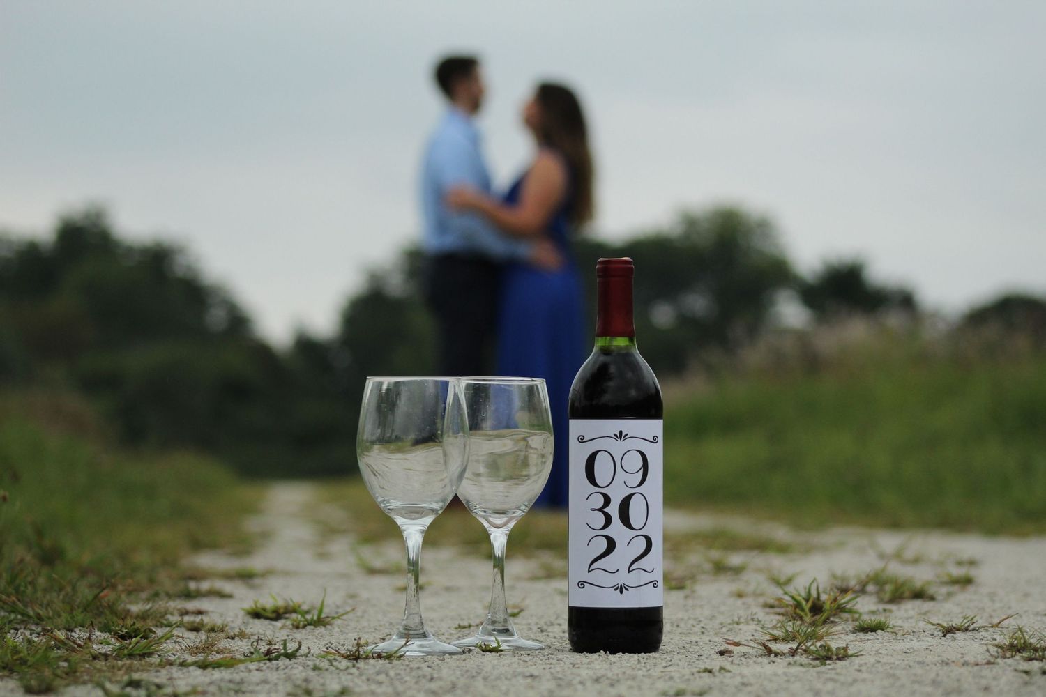 Detail photo of wine bottle propr with couple in background