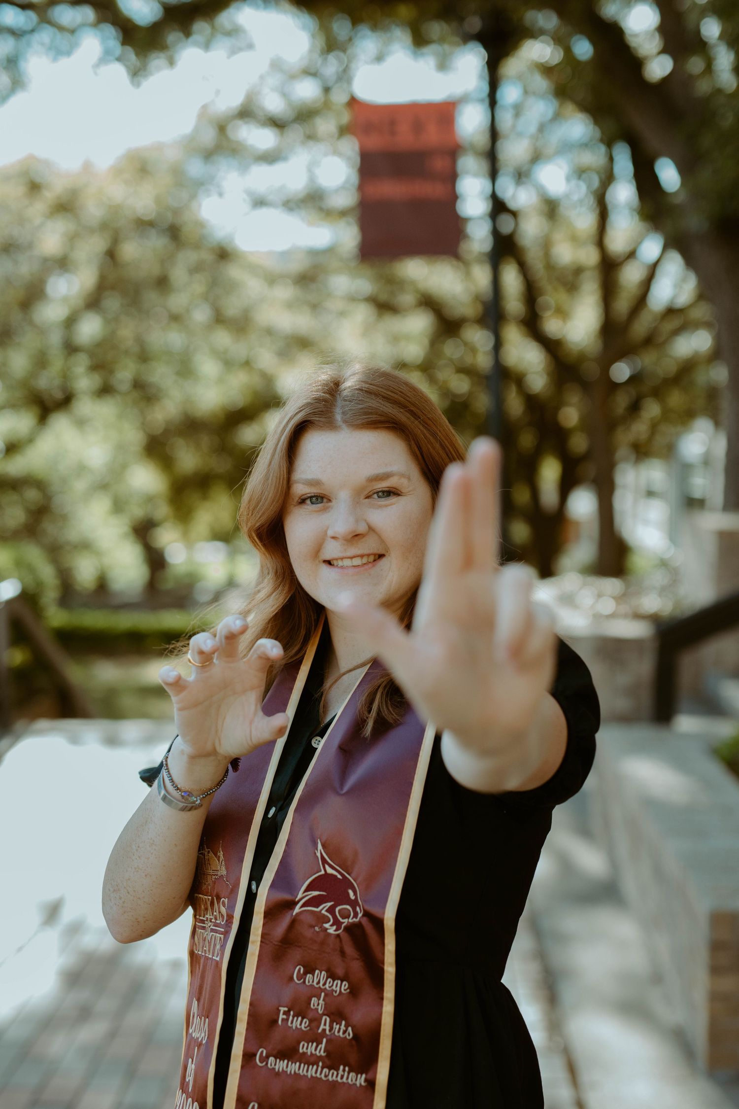 Close-up portrait of a Texas State senior flashing the 