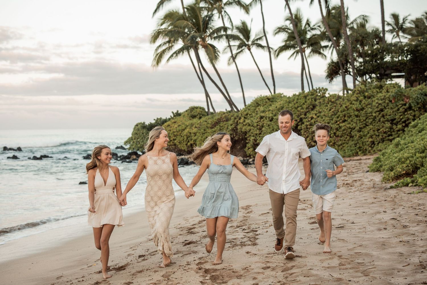 family of five walking hand in hand on Maui beach