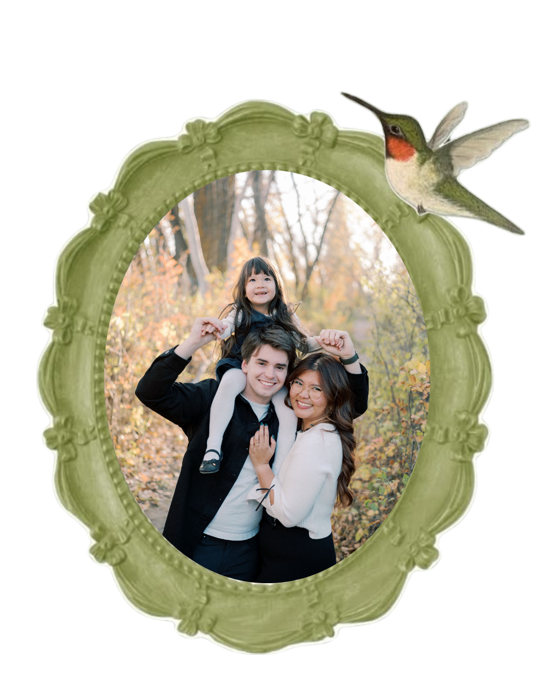 Family portrait in green ornate oval frame with hummingbird, showing couple and child outdoors among autumn foliage.