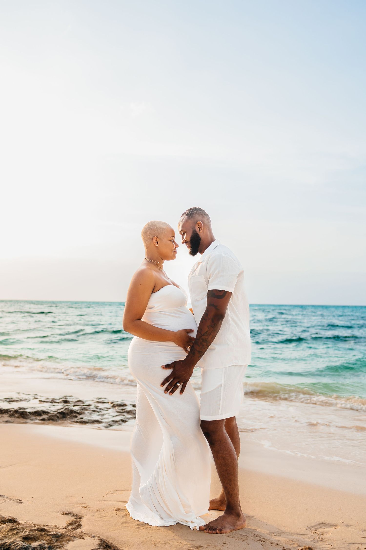Intimate beachside portrait with turquoise ocean waves and sandy shore.