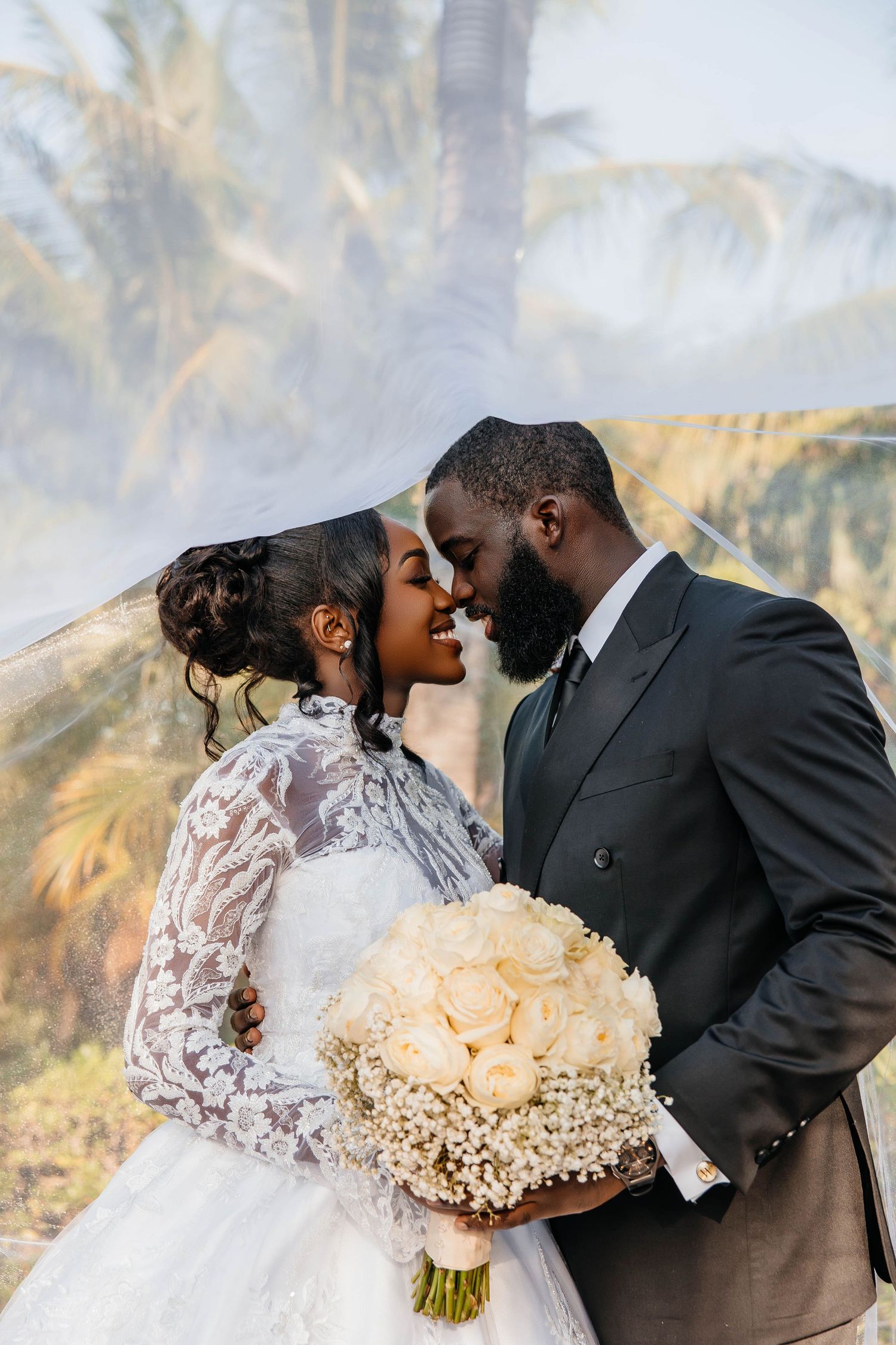 An intimate wedding portrait showcasing a beautiful bouquet of cream roses.