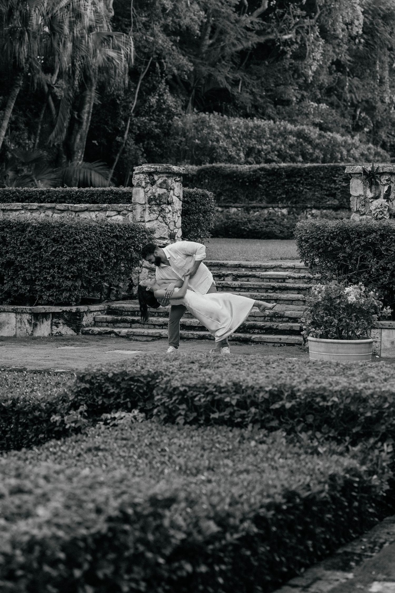 Black and white photo of figure in flowing dress on garden stone steps.