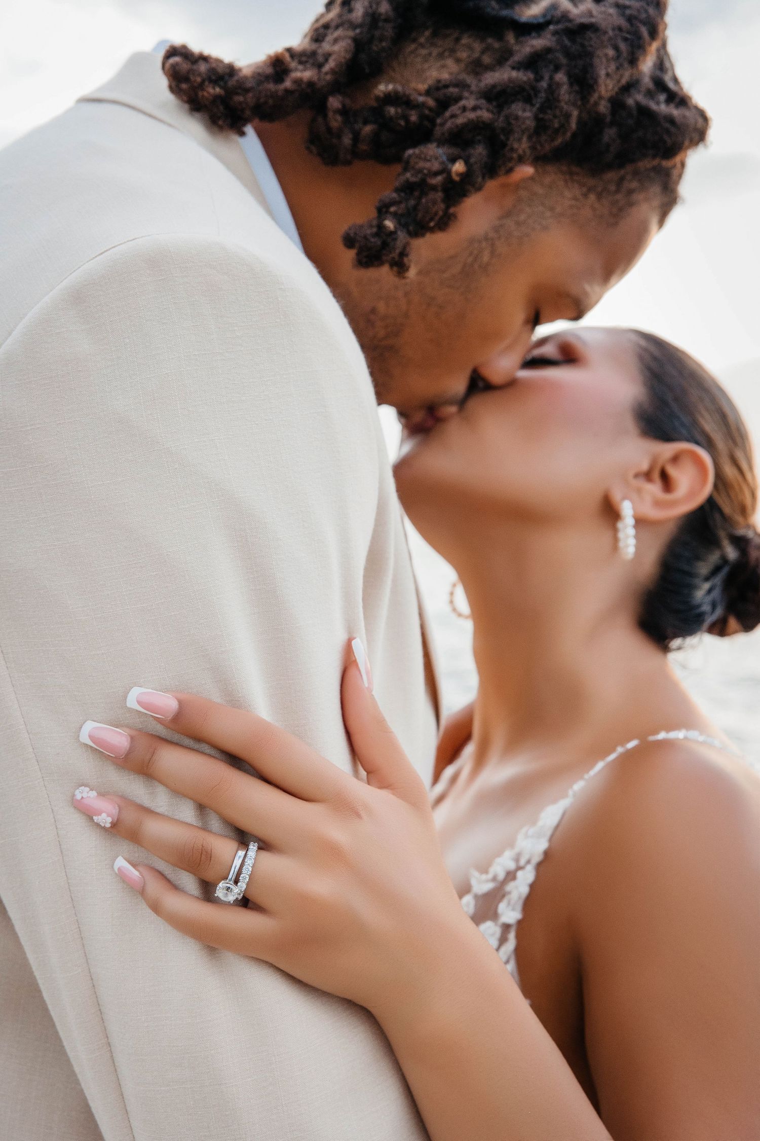 Romantic close-up of newlyweds sharing an intimate moment, showcasing wedding ring and details.