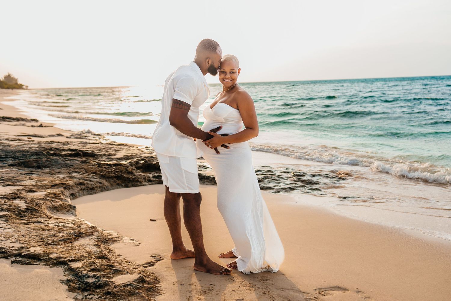 Romantic beach moment captured at sunset with ocean waves in background.