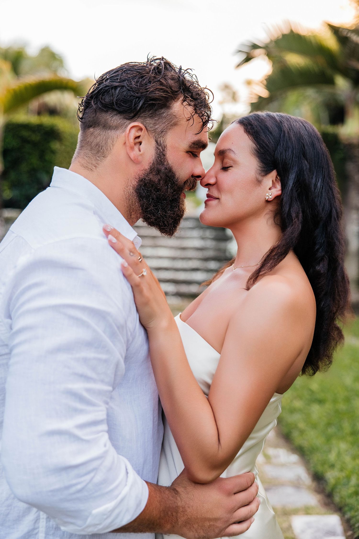 A tender moment between a couple against a garden backdrop.
