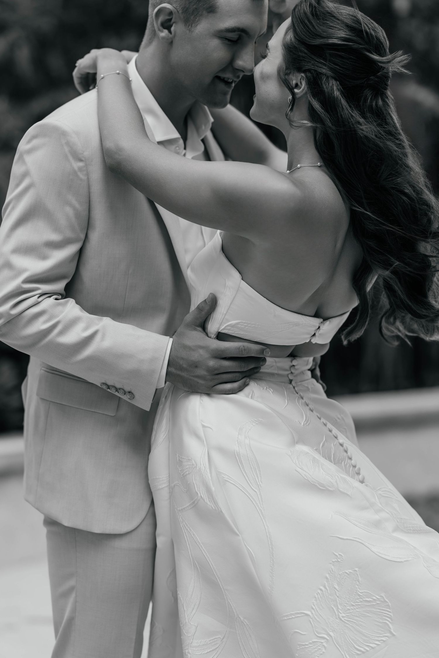 A romantic black and white wedding photo sequence showing a couple dancing and embracing in formal attire.