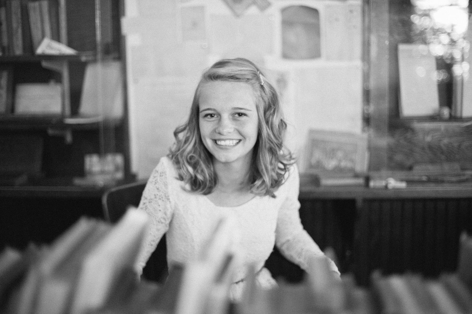Black and white candid portrait with joyful expression in vintage setting.