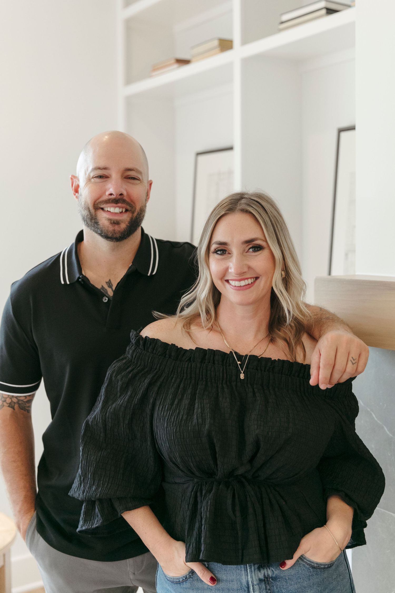 Casual lifestyle portrait in front of white built-in shelves and modern fireplace.