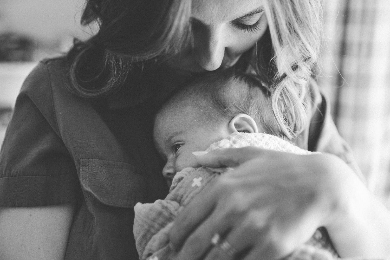 Black and white photo series showing tender moments between a mother and newborn baby in intimate close-up shots.