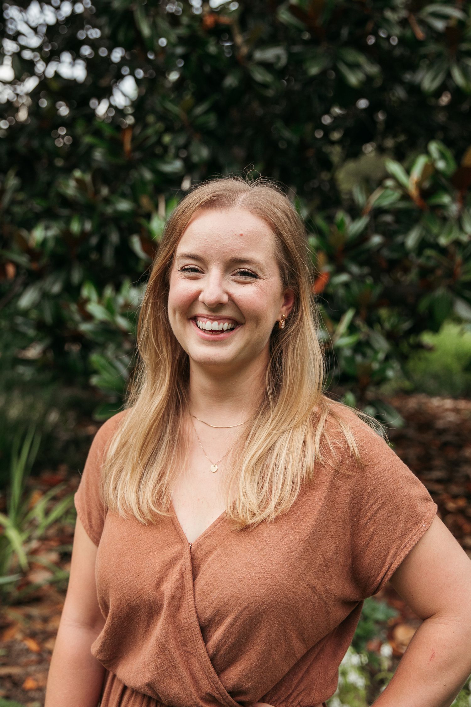 Multiple angles of a casual outdoor portrait in front of dark green foliage wearing a brown v-neck top.