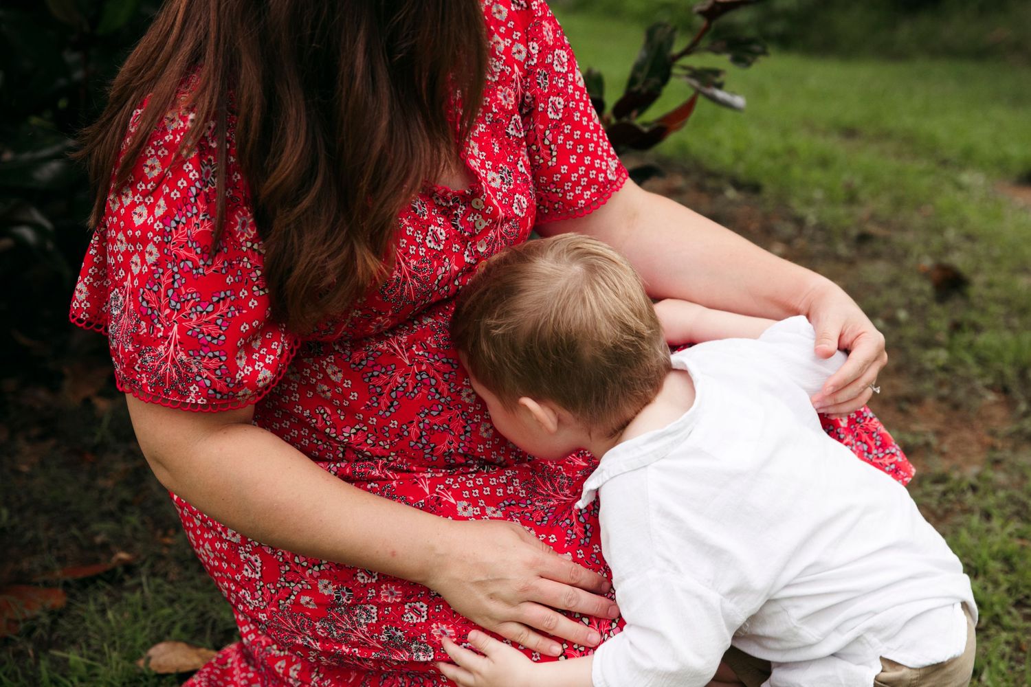 Close-up shot of family sharing tender moment outdoors during photo session.