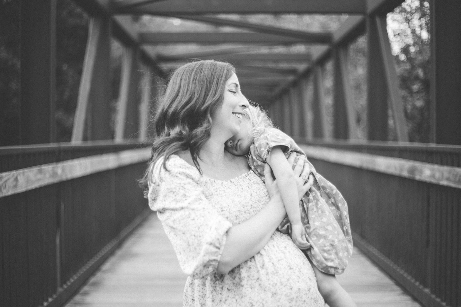 Black and white photo of a tender moment on a covered bridge.