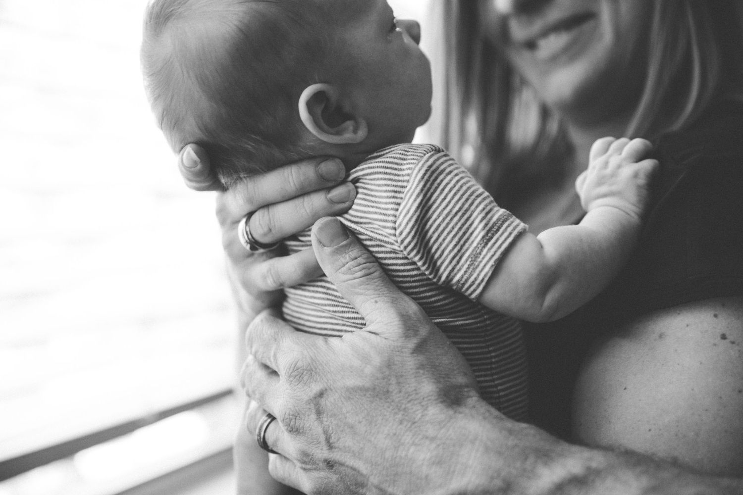 Black and white candid moment captured by window with natural lighting.