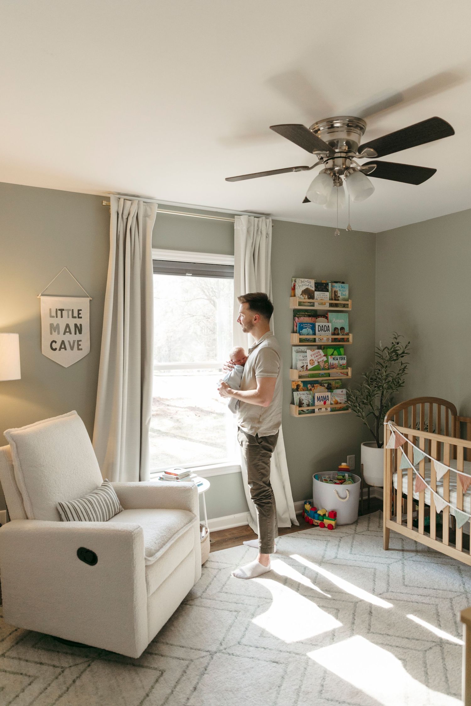 Bright modern nursery with white furniture, geometric rug, and natural lighting.