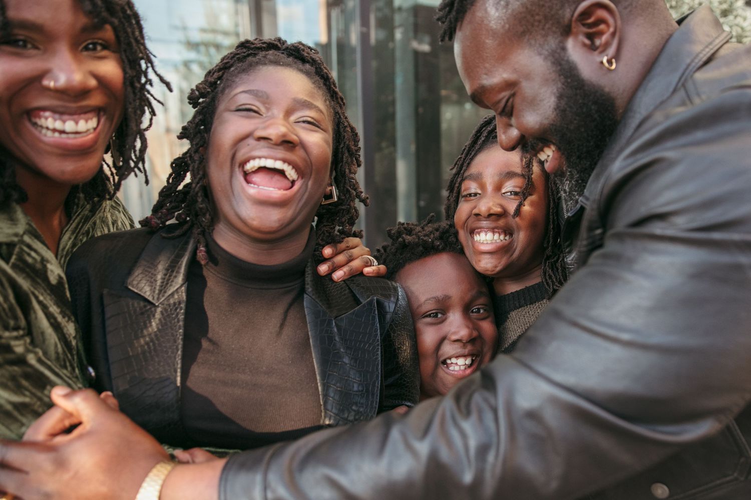 Group sharing genuine laughter and joy while huddled together outdoors.