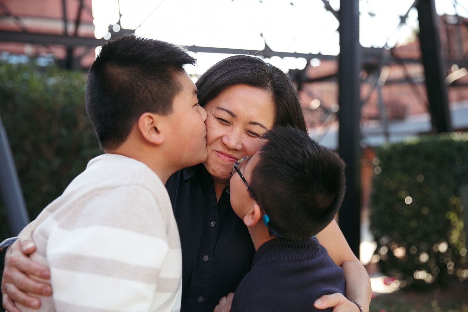 An intimate family moment captured outdoors with warm embraces and expressions of love.