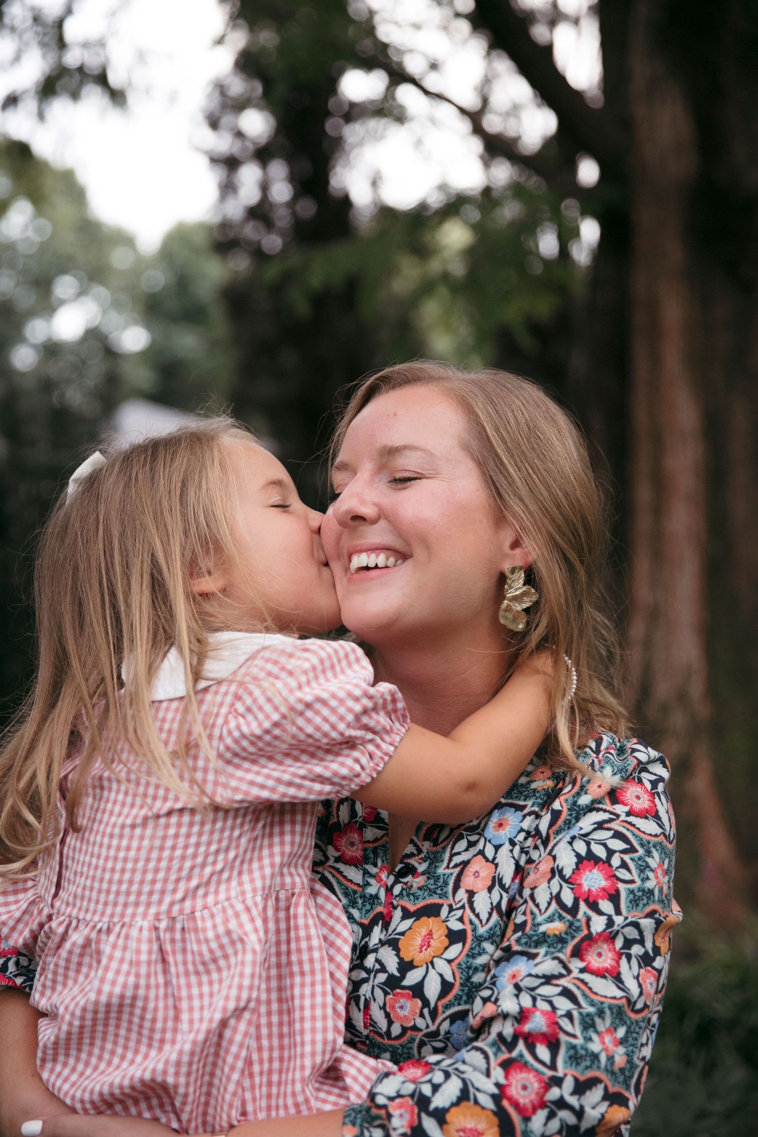 Intimate moment of tenderness and laughter captured during outdoor photo session.