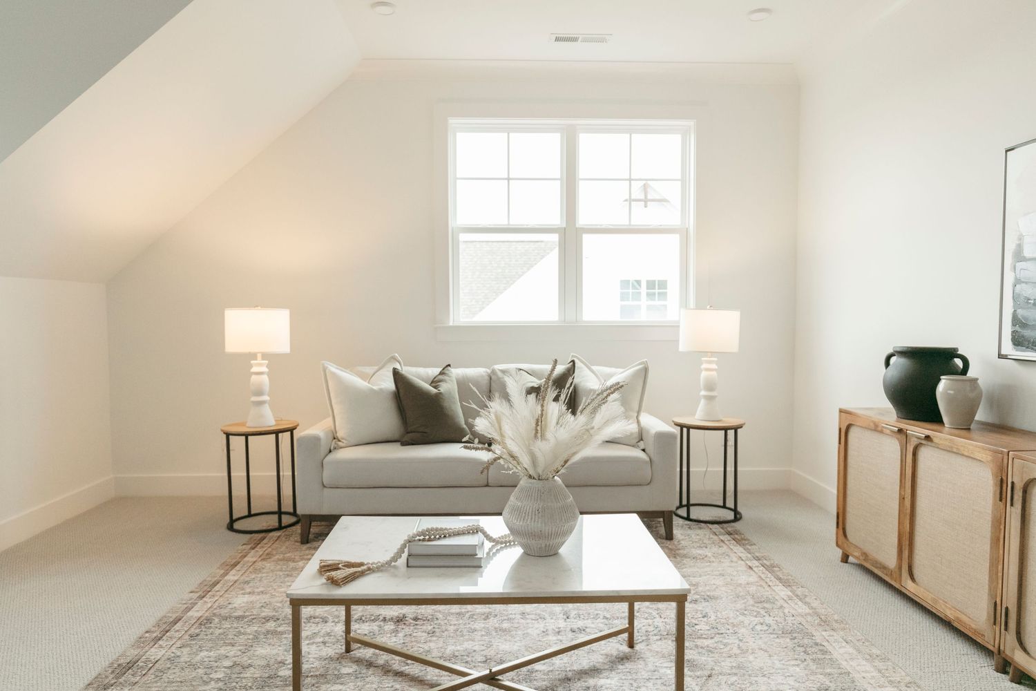 Spacious white living room with high ceilings and modern furnishings.