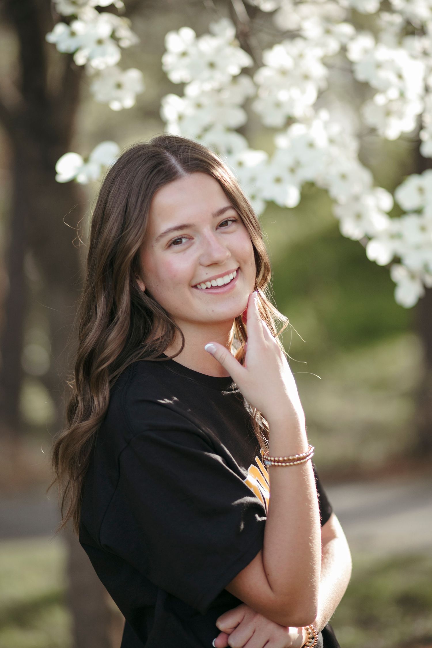 Spring portrait with blooming white cherry blossoms in background.