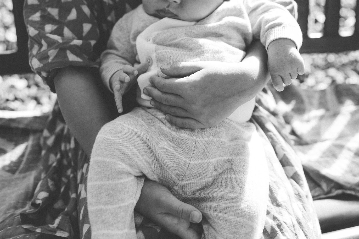A series of black and white photos showing tender moments between a parent and baby.