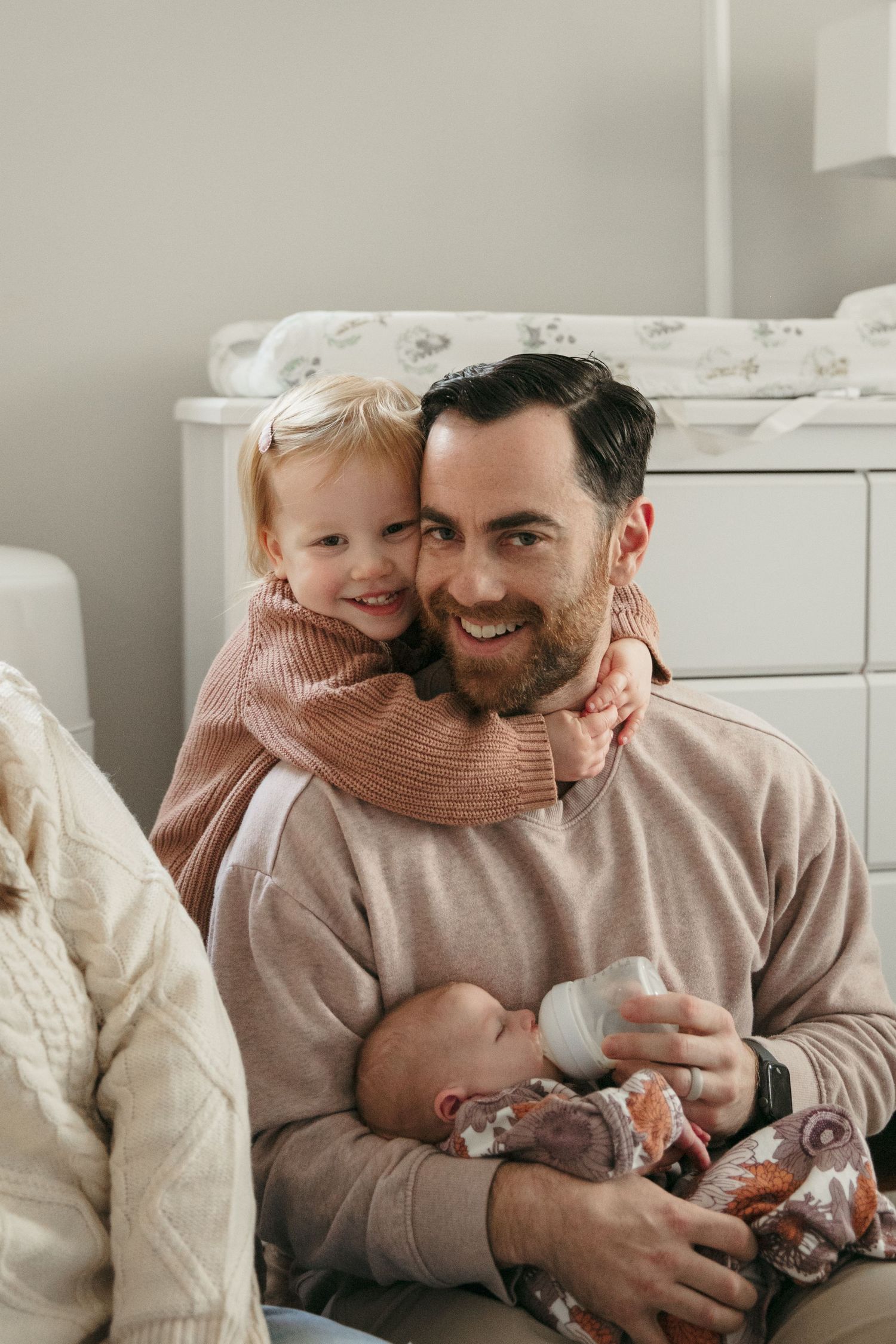 Sweet family bonding moment with a baby and toddler in a cozy nursery setting.