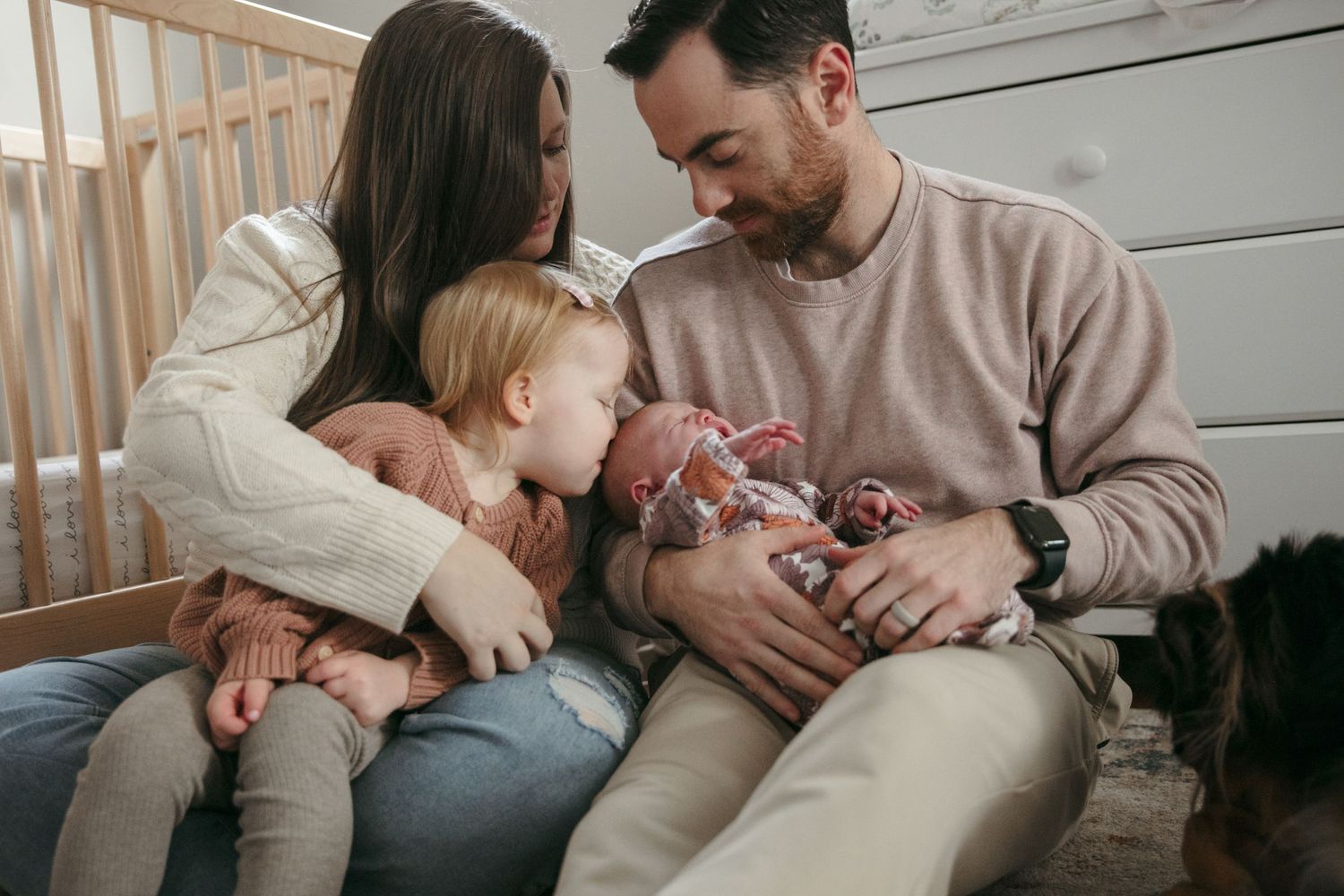 Parents snuggle and bond with their newborn baby on a couch in an intimate lifestyle photoshoot.
