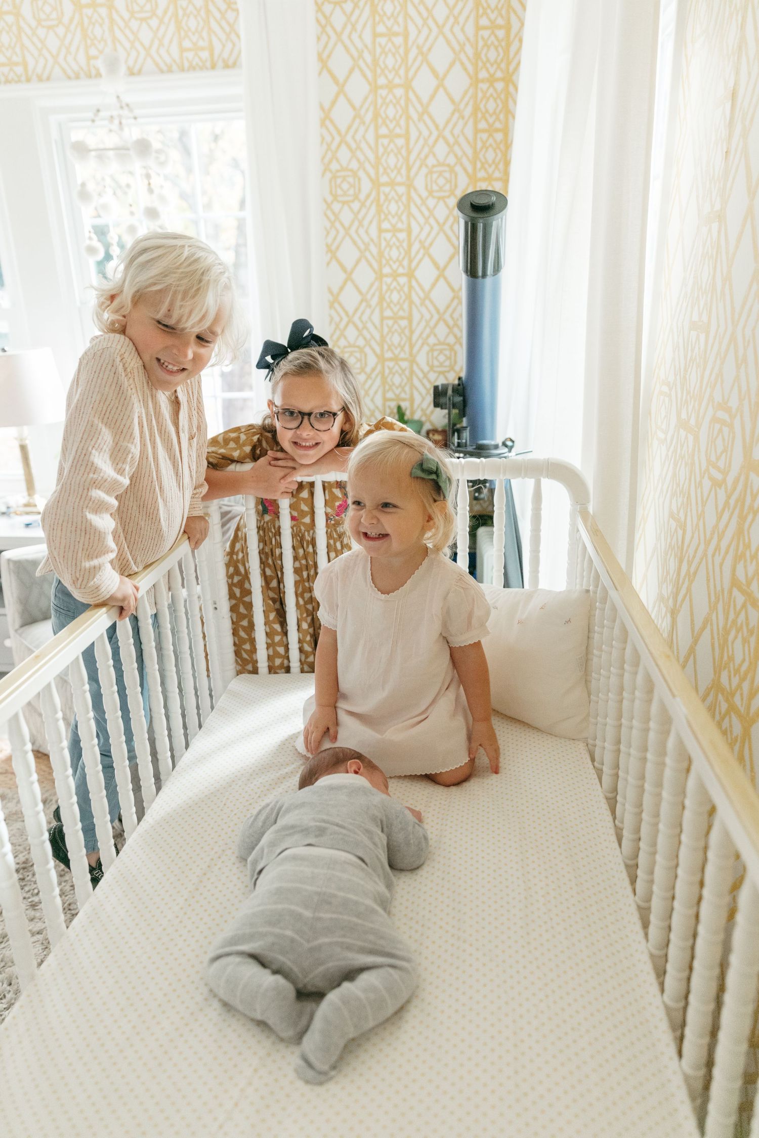Candid sequence showing joyful playtime between parent and child in a white-railed crib.