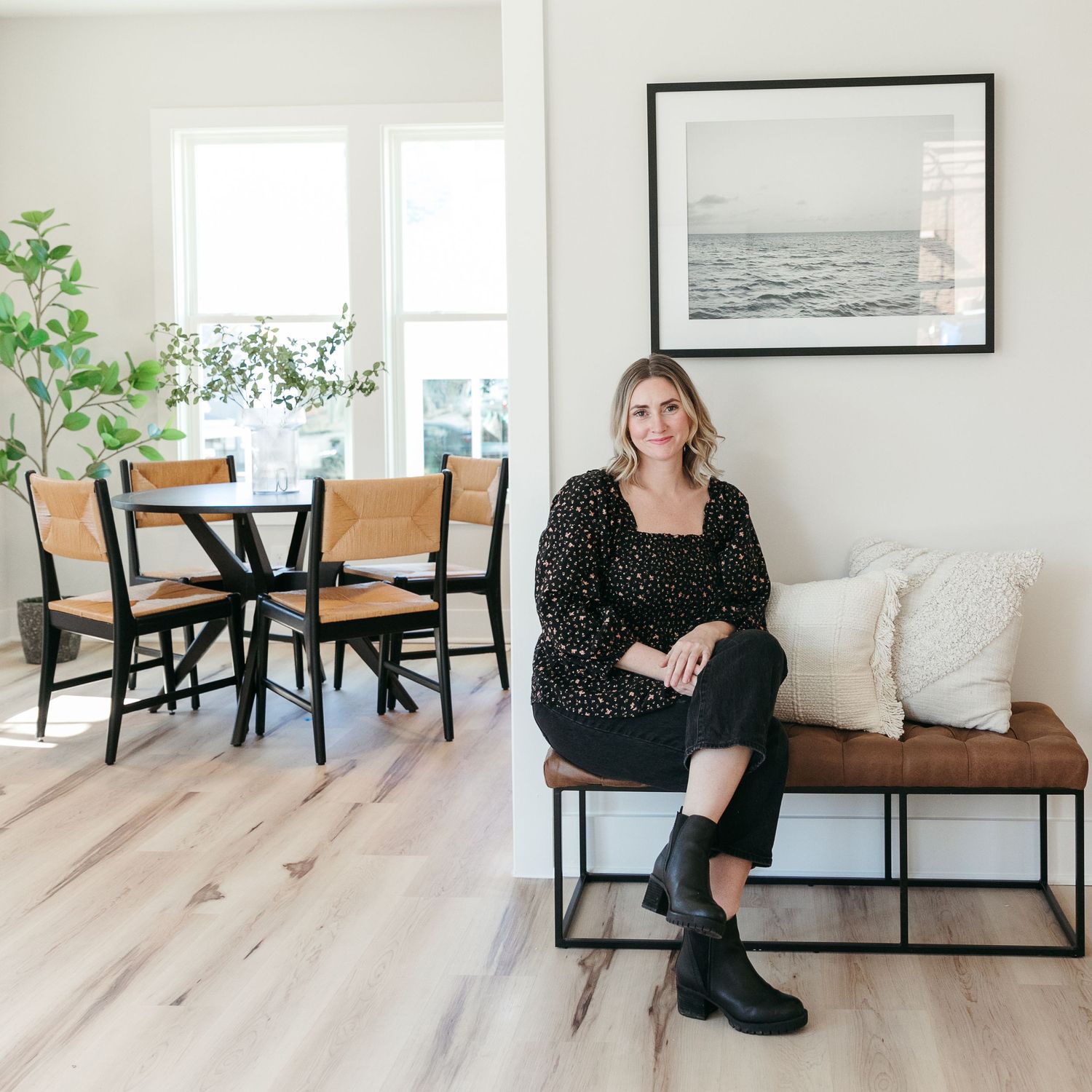 Modern minimalist interior shots showing a bright room with wood floors and black dining furniture.
