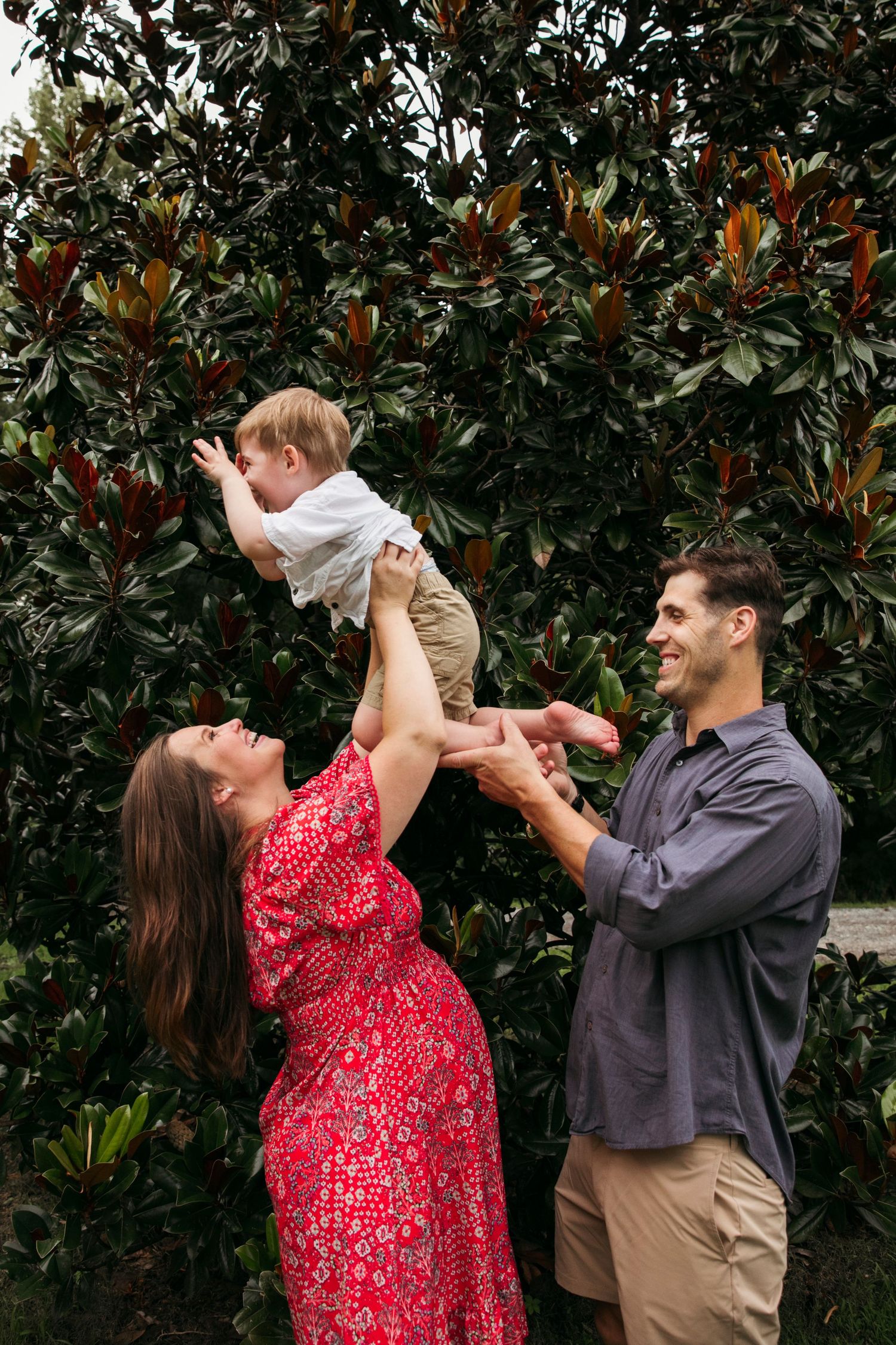 A joyful family moment playing in front of a magnolia tree in their backyard.