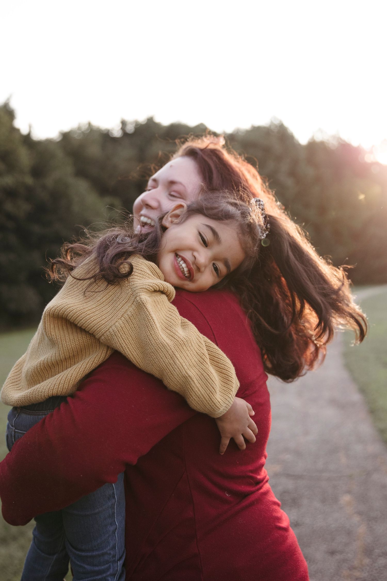A heartwarming embrace between two people captured in golden sunset lighting.