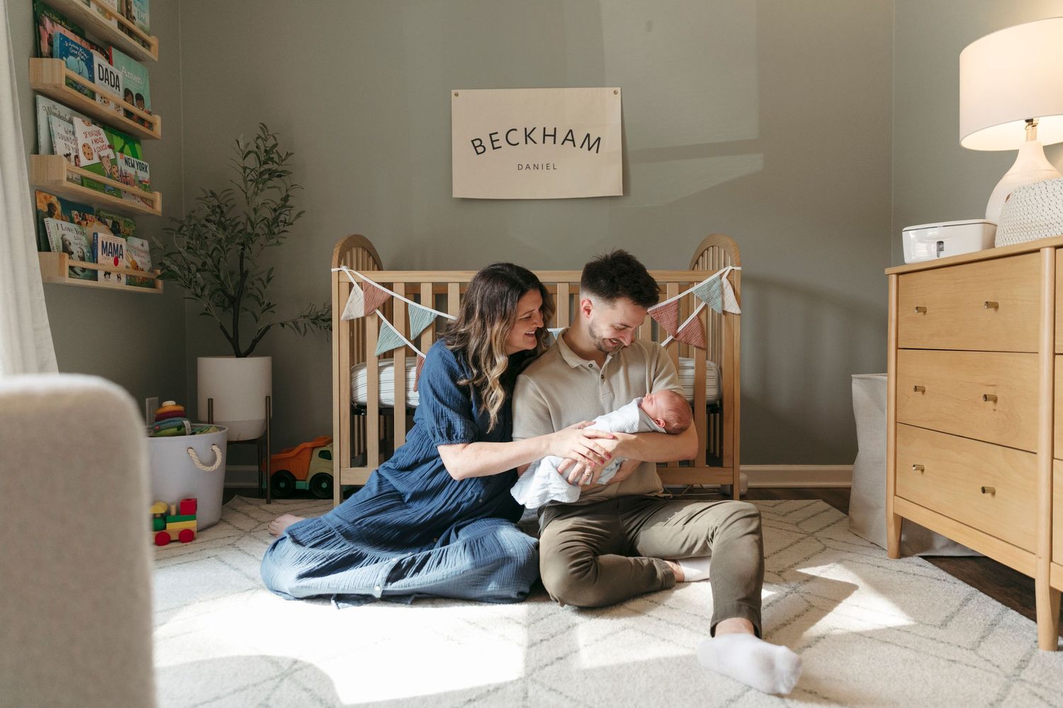 Modern nursery room with natural light streaming through windows and white furniture.