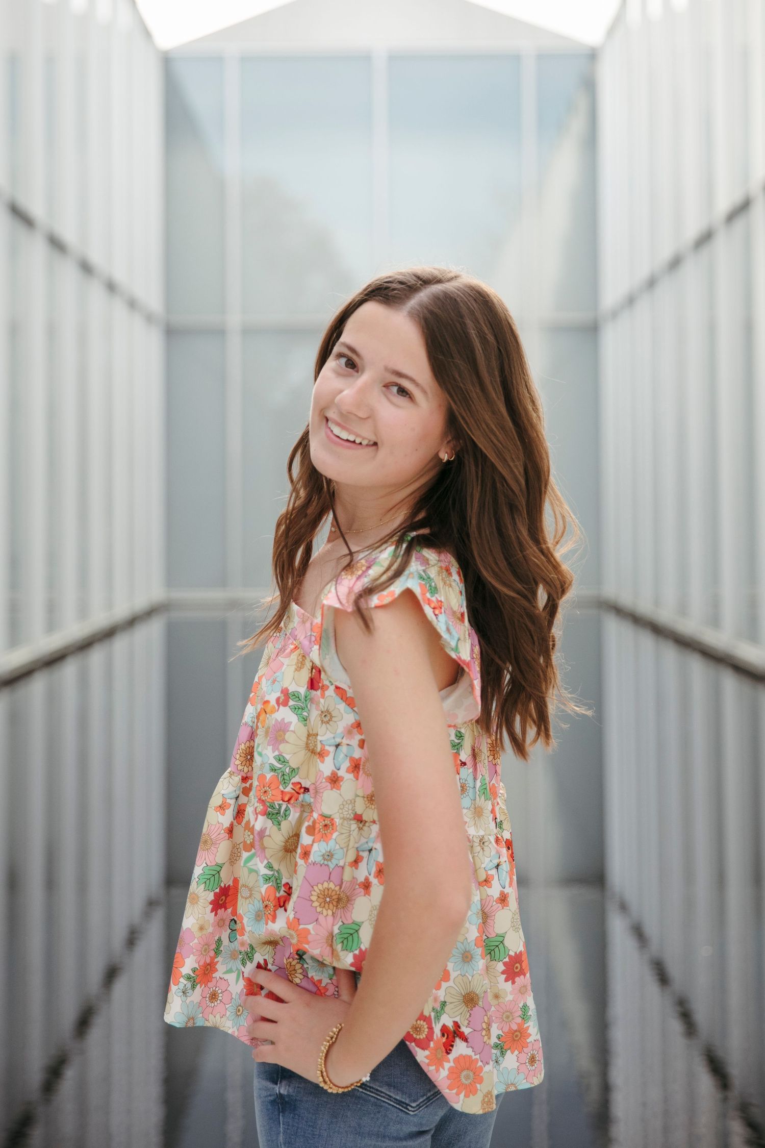 Portrait in modern corridor with metal walls and natural lighting.