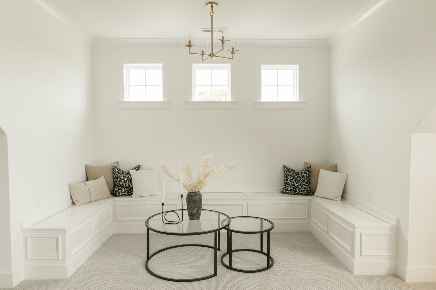 Elegant living room featuring wainscoting, built-in seating, and natural light from multiple windows.