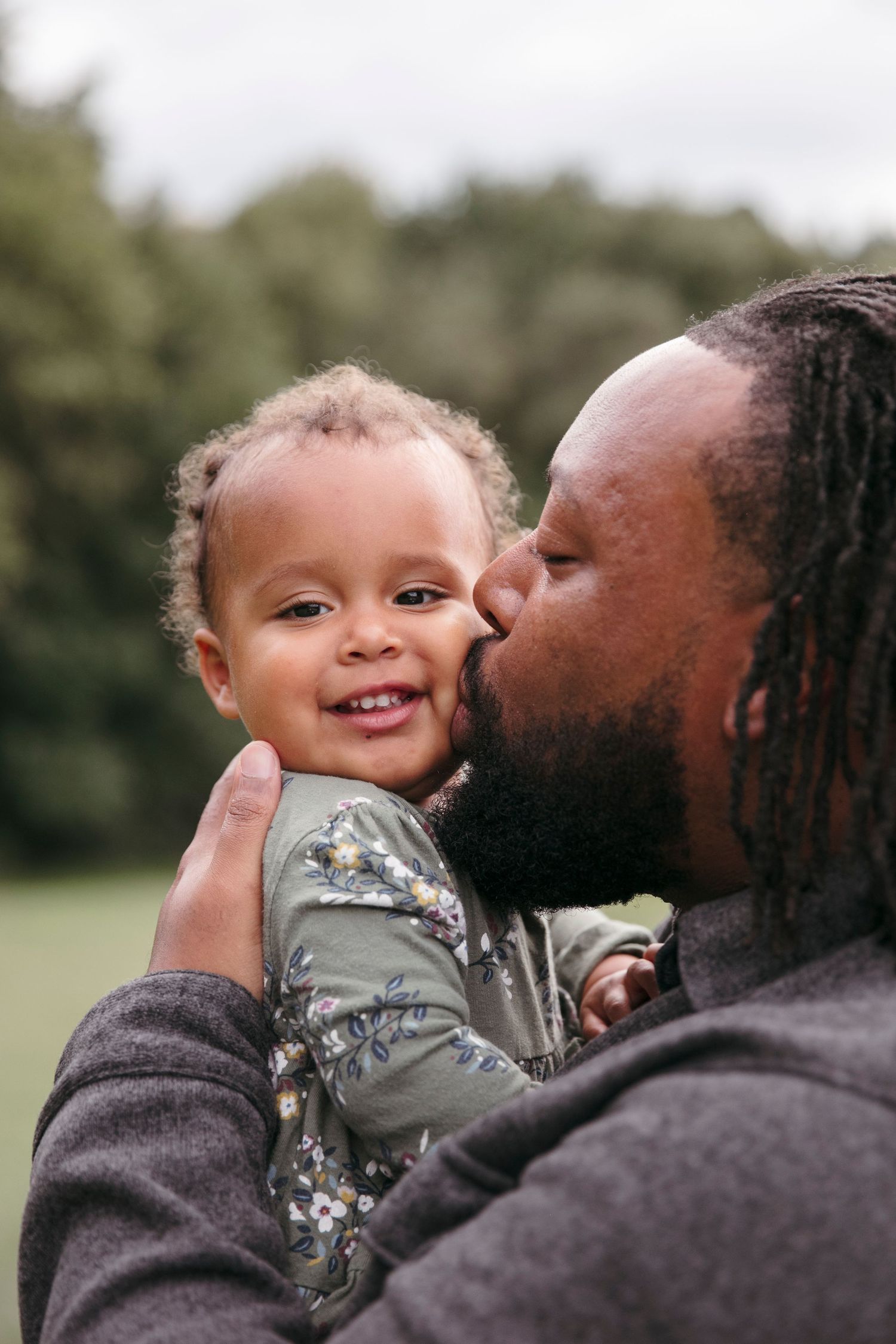 A tender moment of affection captured between parent and child outdoors.