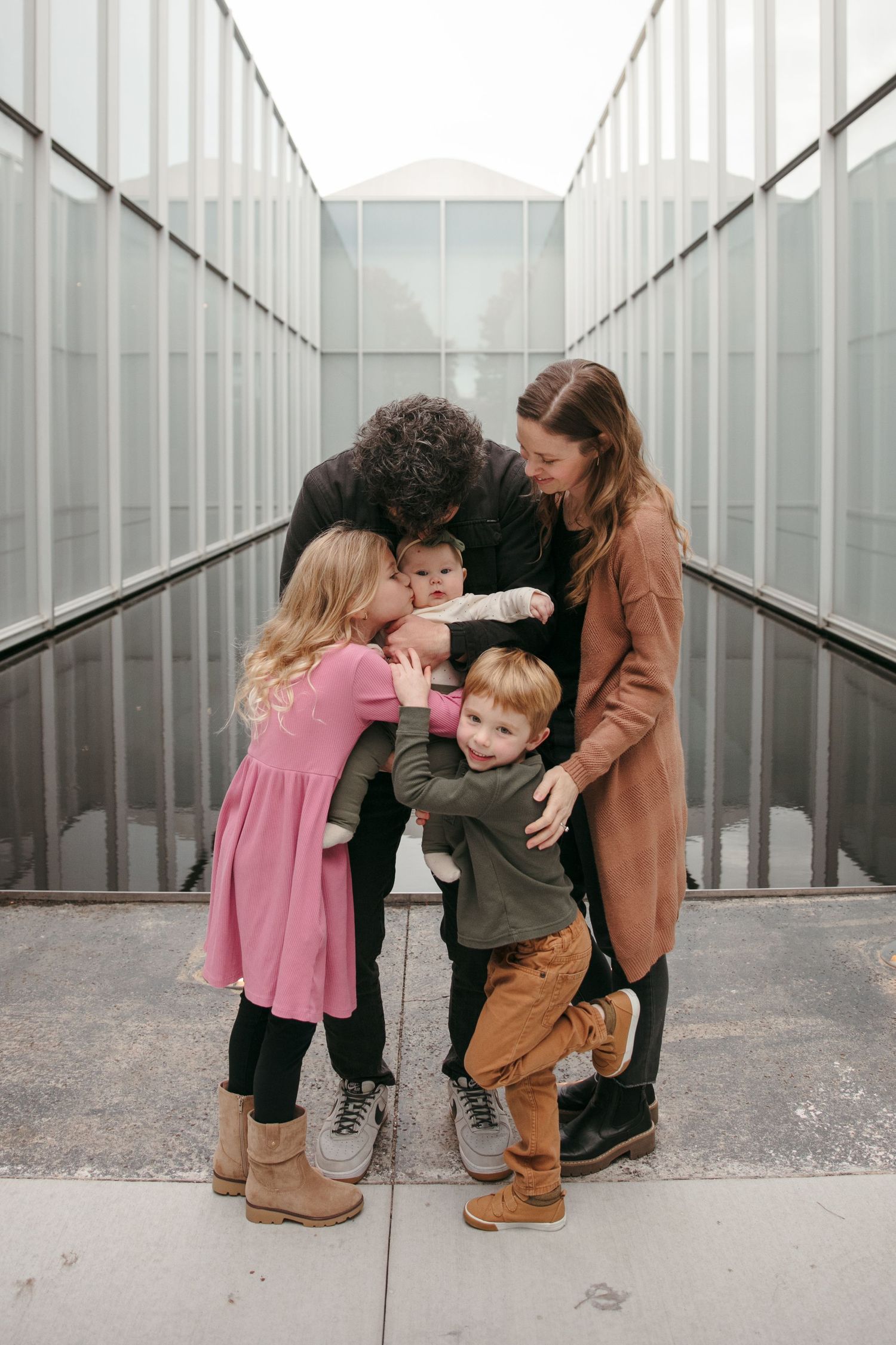 Family sharing a tender moment together in an industrial hallway setting.