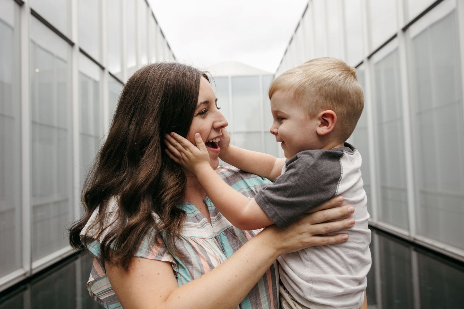 Parent and child sharing joyful moment while playing in modern hallway.